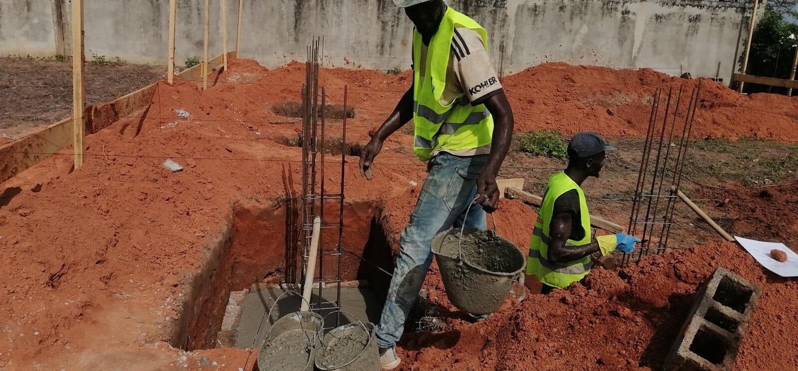 Équipe ARCHIPROBAT coulant les fondations d'un chantier à Dakar